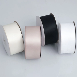 Detailopname van 4cm satijnen polyester linten in crème, roze, zwart en wit voor decoratie