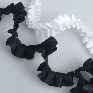 Macro detail of 2.5cm pleated polyester lace ribbon in black and white colors