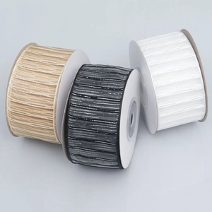 Detailed view of champagne, black, and white ribbons with metallic threads and ribbed texture