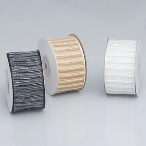 Close-up of striped ribbon rolls in black, champagne, and white for gift wrapping