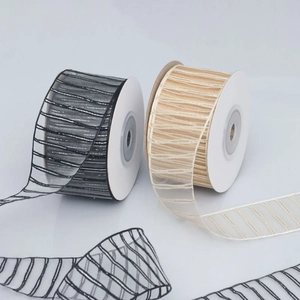 Detailed close-up of champagne and black striped organza ribbons for DIY gift wrapping