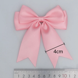 Pink double-layered polyester satin bow with swallowtail ribbons, 10cm wide on grey background