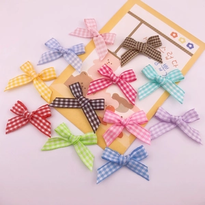 Colorful plaid ribbon bows for DIY crafts and gift box decoration on floral card