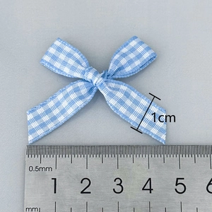 Blue and white gingham checkered ribbon bow with ruler showing size measurement