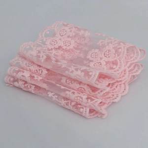 Detailed view of pink embroidered lace trim with delicate floral patterns for garments