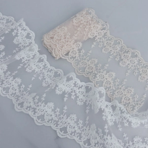 Detailed macro view of 13cm white and beige floral embroidery lace with scalloped edges