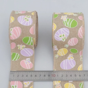 Detail of 6.3cm wide burlap ribbon with colorful Easter egg patterns and wire edges