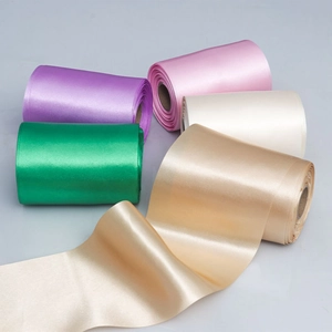 Close-up of multicolored satin ribbons for gift wrapping and DIY crafts in five vibrant shades