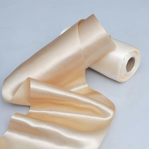 Close-up of champagne gold satin ribbon with glossy silk texture for wedding decor