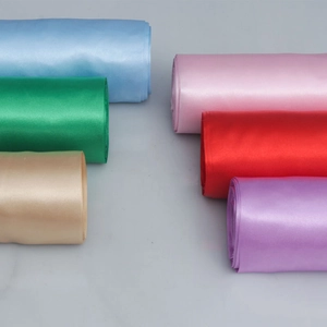 Close-up of vibrant satin ribbon rolls in multiple colors for wedding chair and gift decor
