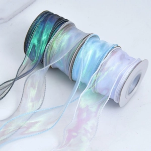 Macro shot of iridescent organza ribbon roll with rainbow gloss for DIY gift wrapping