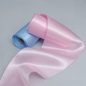 Detailed view of pink and light blue satin ribbons with smooth glossy finish and soft drape