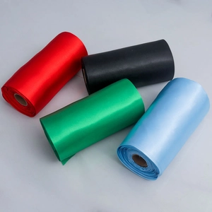 Detail view of colorful satin ribbon rolls in red, black, green and blue for gift wrapping