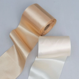 Detail of high-density wide satin ribbons in champagne gold and ivory white colors