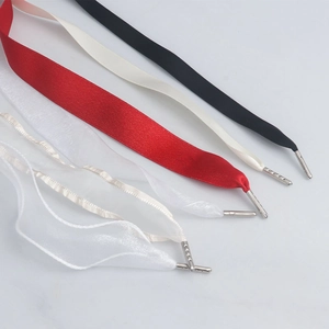 Detailansicht bunter Satinbänder und Organza-Schnürsenkel mit silbernen Metallspitzen