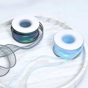 Close-up of iridescent organza ribbon rolls in gradient blue and white for gift wrapping