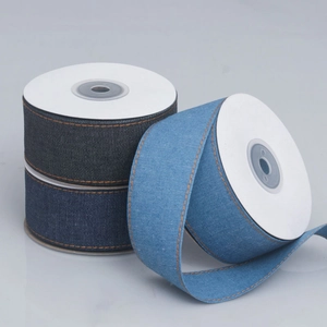 Three rolls of denim fabric ribbon with orange contrast stitching for DIY crafts