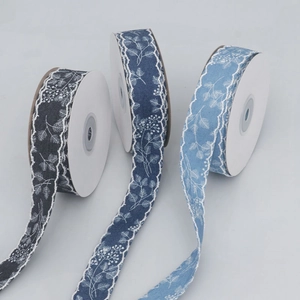 Detail view of denim texture printed ribbons with white lace edges and floral leaf patterns