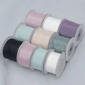 Macro detail of assorted organza ribbon rolls in soft pastel colors for DIY gift wrapping