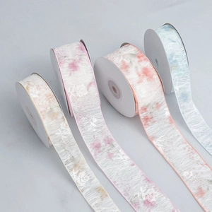 Macro shot of semi-transparent organza ribbons with white floral prints in four pastel colors