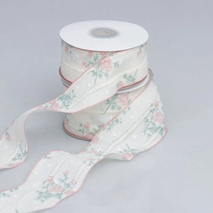 Close-up of floral lace ribbon with rose patterns and pink scalloped edges for DIY crafts