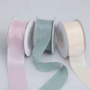 Detail of sheer organza ribbons in pink, teal, and beige for gift wrapping and DIY crafts
