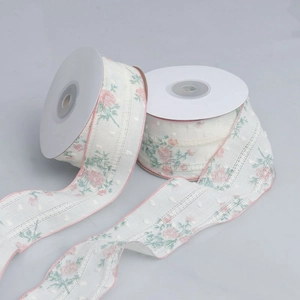 Detail of floral lace ribbon with pink rose print and textured polka dot embroidery