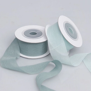 Detail of light blue organza ribbon with shimmer texture on two white plastic spools