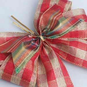 Close-up of red plaid burlap bow with gold wired edges for Christmas tree decoration