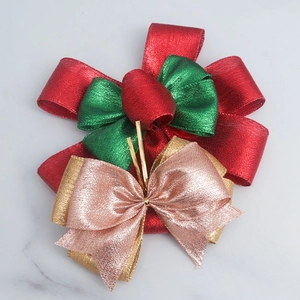 Detail of glittery Christmas bows in red green gold and pink with metallic wire texture