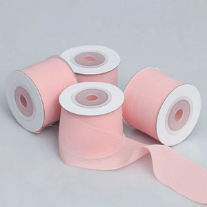 Close-up of four rolls of pink semi-sheer chiffon ribbons for DIY craft and gift wrapping