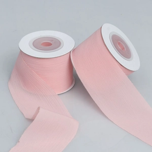 Detail of pink sheer organza ribbon rolls showing fine texture and raw edge finish