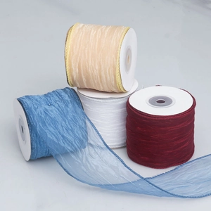 Detailed view of pleated mesh ribbons in blue, beige, white, and wine red rolls
