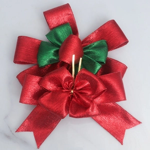 Sparkling red and green layered burlap Christmas bow with gold wire on marble background