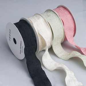 Macro shot of 4cm pleated ruffle ribbons in four colors on white spools for gift wrapping
