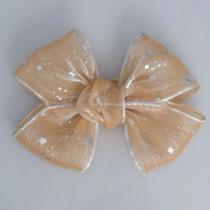 Macro detail of starry orange gold mesh ribbon with silver glitter star patterns