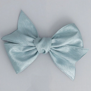 Detail of light blue herringbone textured ribbon bow with metallic luster finish