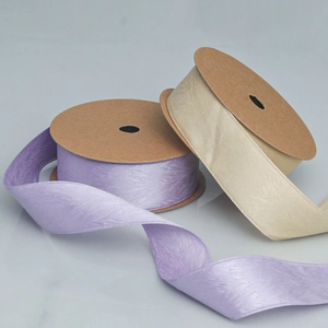 Detail of lavender and champagne ribbons with herringbone texture on a roll for DIY gifts