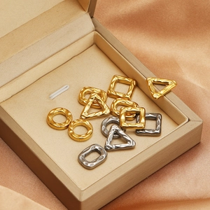Hammered geometric stainless steel charms in gold and silver on beige velvet