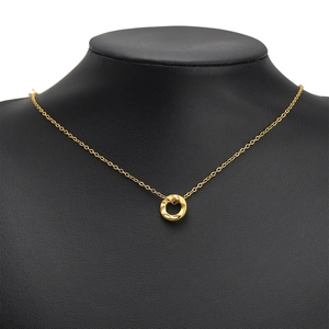 Gold stainless steel necklace with textured circular pendant on a black bust mannequin