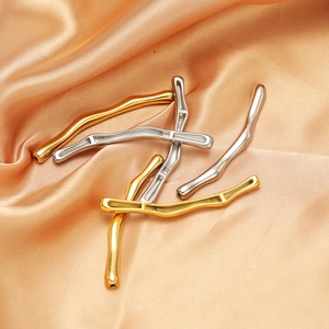 Gold and silver curved bamboo tube charms in polished steel on champagne satin fabric