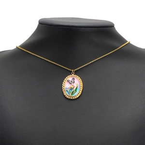 Collana con ciondolo ovale dorato vintage con farfalla nera e arte floreale smaltata