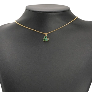 Gold plated necklace with green heart-shaped clover pendant on black mannequin stand