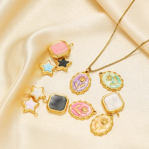 Star and tulip enamel pendants in assorted colors on elegant silk fabric background
