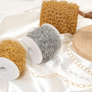Gold and silver stainless steel chain spools for DIY jewelry making on silk background