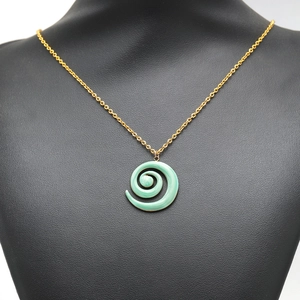 Spiralform grüner Emaille Anhänger mit Goldkette auf schwarzem Büstenständer
