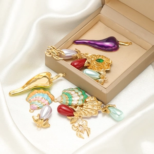 Assorted chili pepper and seashell charms on silk background with jewelry box