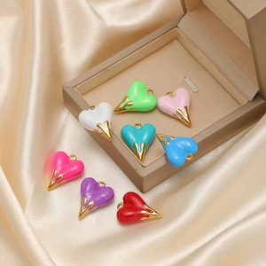 Enamel heart charms in multiple colors with gold finish on silk background