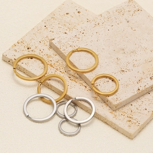 Flat 18k gold and silver stainless steel key rings in various sizes on a stone base