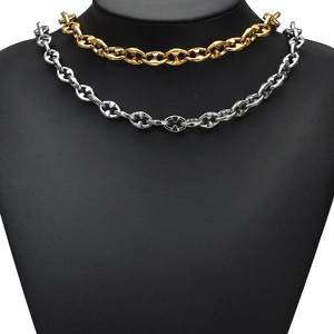 Polished gold and silver coffee bean pig nose chain necklaces on a black display stand